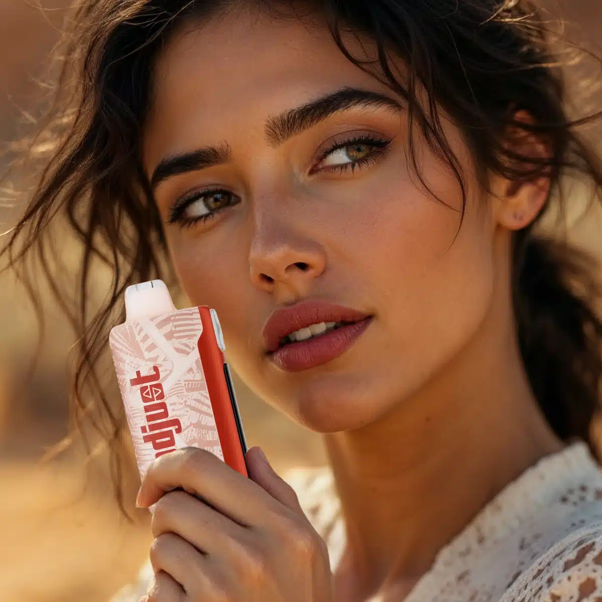 A woman with brown hair holding a Lost Mary Adjust MySweet vape in Watermelon Roll-Ups flavor near her face and looking relaxed.